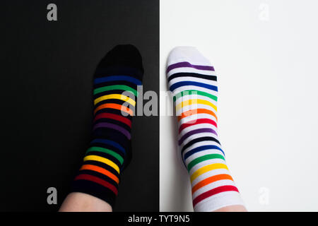 Legs with white and black striped new clean colorful textile socks. Fashion accessories for feet with negative background with copy space. Flat lay Stock Photo