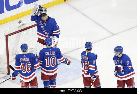 New York Rangers Alexandar Georgiev puts on his mask while Rob O'Gara, J.T. Miller, Marc Staal and Jesper Fast stand near the goal in the second period against the Minnesota Wild at Madison Square Garden in New York City on February 23, 2018.     Photo by John Angelillo/UPI Stock Photo