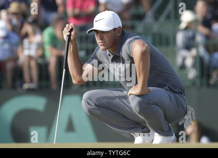 Tommy Fleetwood of England lines up a putt on the third hole during the ...