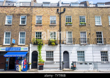 Gray's Inn Road, Camden,London, UK - May 2019: Facade of Edwardian Victorian restored residential houses in yellow bricks with off licence store shop Stock Photo