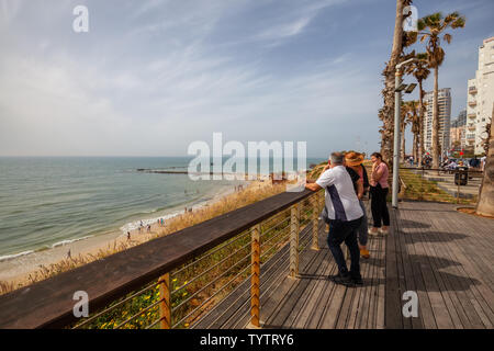 Tel Aviv, Israel - April 13, 2019: Beautiful view of a crowded beach in a modern city during a cloudy and sunny day. Stock Photo