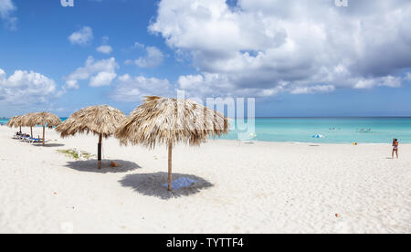 Varadero, Cuba - May 8, 2019: Beautiful panoramic view of the sandy beach  underneath a shade umbrella during a vibrant sunny day.