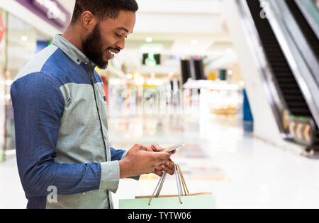 Smiling african american guy searching through the Internet Stock Photo