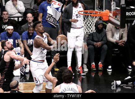 Philadelphia 76ers forward Jimmy Butler, center, shoots over Brooklyn Nets guard Joe Harris, left, during the first half  game between the Philadelphia 76ers and the Brooklyn Nets in Game 3 of their first-round playoff series at Barclays Center in New York City on April 18, 2019.       Photo by Peter Foley/UPI Stock Photo