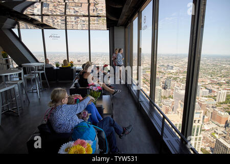 visitors looking out from the bar area of the observation deck of 360 chicago the john hancock building Chicago IL USA Stock Photo