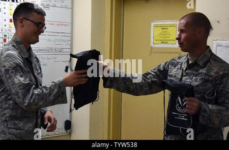 Master Sgt. Michael Bergquist, a chaplain assistant with the 379th Air Expeditionary Wing, right, gives Senior Airman Jeremy Whitfield, a ground radar technician with the 727th Expeditionary Air Control Squadron, Detachment 3, during the monthly “blitz,” at Al Udeid Air Base, Qatar, Nov. 30, 2016. The blitz is organized to reach out to Airmen that work the night shift because they don’t usually have the same opportunity to interact with helping agency team members that day shift Airmen do. Stock Photo