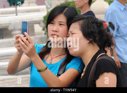A daughter shows her mother the picture she took with her camera phone at the entrance to the Forbidden City in Beijing on August 4, 2008.  Chinese and foreign Olympic visitors flocked to the tourist areas near the Forbidden City, which is adjacent to Tiananmen Square prior to start of the Summer Olympic games on August 8th.     (UPI Photo/Pat Benic) Stock Photo