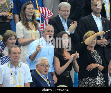 United States President George W. Bush waves an American Flag as he watches USA's Michael Phelps during the Men's 400M Individual Medley Final where Phelps set a World Record of 4:03.84 at the National Aquatics Center at the Summer Olympics in Beijing on August 10, 2008.  Phelps won the first of a possible eight gold medals at the games.  At left is First Lady Laura Bush and to next to the president is his daughter Barbara.  Former Secretary of State Henry Kissinger is in front.   (UPI Photo/Pat Benic) Stock Photo