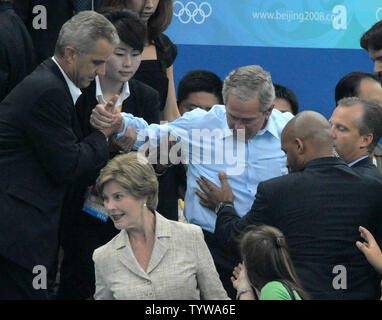 Secret Service agents react quickly when United States President George W. Bush slips on his way to his seat with First Lady Laura Bush to watch the swimming at the National Aquatics Center at the Summer Olympics in Beijing on August 10, 2008.    (UPI Photo/Pat Benic) Stock Photo