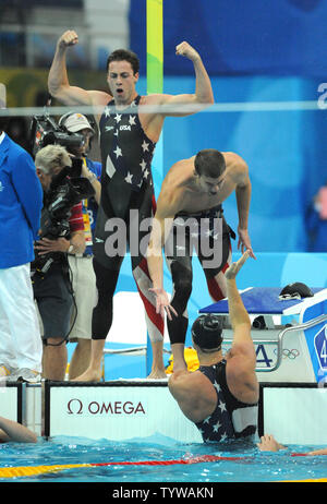 USA's Michael Phelps shakes hands with teammate Jason Lezak as teammate Garrett Weber-Gale cheers at the finish of the Men's 4x100M Relay Final at the National Aquatics Center at the Summer Olympics in Beijing on August 11, 2008.  Lezak came from behind and won a dramatic victory for the United States team, setting a World Record time of 3:08.24.   (UPI Photo/Pat Benic)l Stock Photo