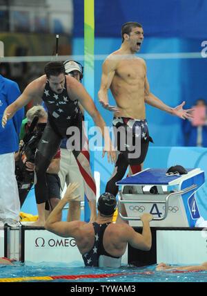 USA's Michael Phelps jubilates as teammate Garrett Weber-Gale congratulates Jason Lezak at the finish of the Men's 4x100M Relay Final at the National Aquatics Center at the Summer Olympics in Beijing on August 11, 2008.  Lezak came from behind and won a dramatic victory for the United States team, setting a World Record time of 3:08.24.   (UPI Photo/Pat Benic)l Stock Photo