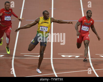 Jamaica's Usain Bolt (C) crosses the finish line to win the gold medal in the men's 100m finals, as American Justin Gatlin (R) wins the bronze medal, at the 2012 Summer Olympics, August 5, 2012, in London, England.  Bolt set an Olympic record with a time of 9.63 seconds. American Ryan Bailey is at (L).                       UPI/Mike Theiler Stock Photo