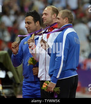 Silver Medalist Ehsan Hadadi of Iran (L-R), Gold Medalist Robert Harting of Germany and Bronze Mealist Gerd Kanter of Estonia pose for photographers during the Men's Discus Throw Victory Ceremony at the London 2012 Summer Olympics on August 8, 2012 in Stratford, London.     UPI/Brian Kersey Stock Photo