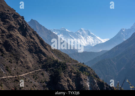 Rough scenery in Himalayas with Mount Everest and Lhotse, narrow hiking path alongside mountain slope