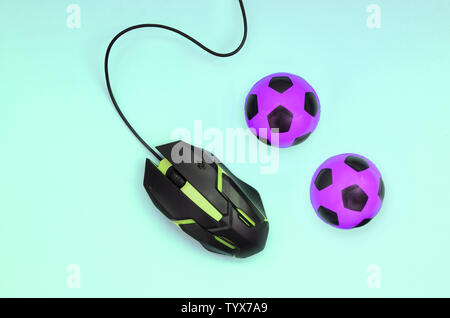 Two soccer balls with computer mouse on blue background. Concept of videogames, eSports, sports betting and online gambling Stock Photo