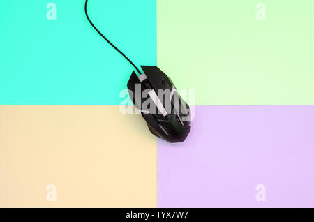 Optical gaming mouse is located between areas of different colors. Device for cybersport and online video games. Flat lay minimal. Top view Stock Photo
