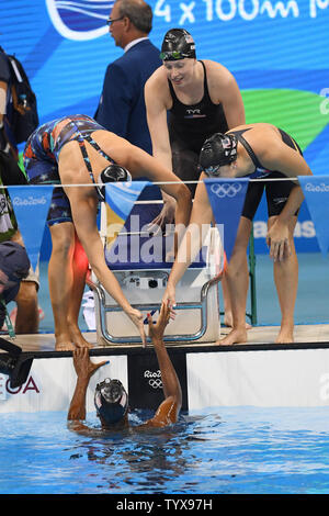 USA's Simone Manuel, is congratulated by teammates Dana Vollmer, left, Lilly King and Kathleen Baker after winning gold in the Women's 4 x 100m medley relay final at the Olympic Aquatics Stadium at the 2016 Rio Summer Olympics in Rio de Janeiro, Brazil, on August 13, 2016.  The United States won the gold medal, Australia the silver and Denmark the bronze.         Photo by Richard Ellis/UPI.. Stock Photo