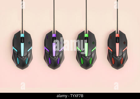 Several computer mice hang on a pastel peach background. The concept of cooperative computer video games, the use of auto-clicker and pay-per-click pl Stock Photo