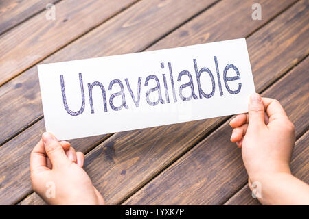 hands hold white paper with word unavailable Stock Photo