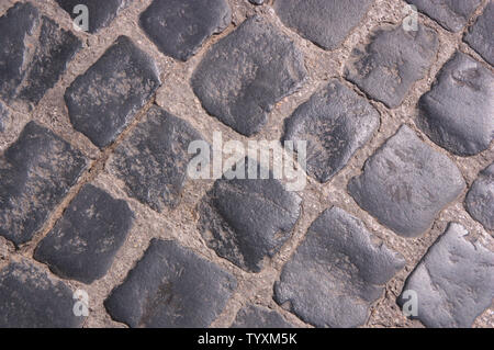 Floor of a dark gray cobblestone city with a diagonal pattern of stones Stock Photo