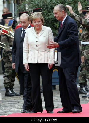 French President Jacques Chirac (R) welcomes German Chancellor Angela Merkel (C) and Russian President Vladimir Putin to review troops before a three-way summit in Compiegne, north of Paris on September 23, 2006. Three leaders have held summit talks in an elegant chateau with economic issues apparently taking priority over Iran 's disputed nuclear programme.  (UPI Photo/Anatoli Zhdanov) Stock Photo