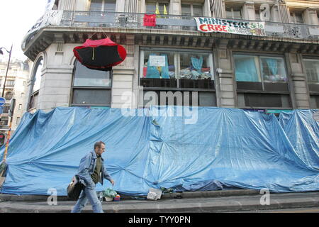 A man walks past a tarp set up to shelter homeless people in Paris, November 27, 2007. Dozens of homeless people have been squatting on 'rue de la Banque' in the center of the French capital in a bid to press the government to find solutions to poor families who can no longer afford to rent following a boom in real estate prices. (UPI Photo/Eco Clement) Stock Photo