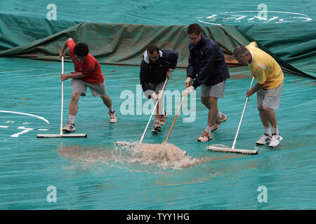 Workers clear water off the tennis court rain protection covers as continued downpours interrupted the matches on the third day of the French Open tennis tournament at Roland Garros Paris, May 27, 2008.   (UPI Photo/Eco Clement) Stock Photo