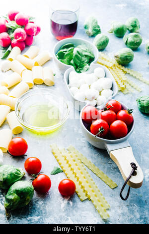 Tomato basil and mozzarella. Food Ingredients pattern with mozarella cheese balls and fresh basil leaves, round cherry tomatoes, with pasta, and wine, Stock Photo