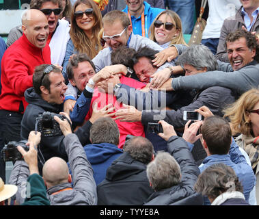 Spaniard Rafael Nadal (red shirt center) is mobbed by his team and family after winning his French Open men's final match against Serbian Novak Djokovic at Roland Garros in Paris on June 11, 2012.  Nadal defeated Djokovic 6-4, 6-3, 2-6, 7-5 in a match that was delayed one day because of rain to win his record 7th French Open title.   UPI/David Silpa Stock Photo