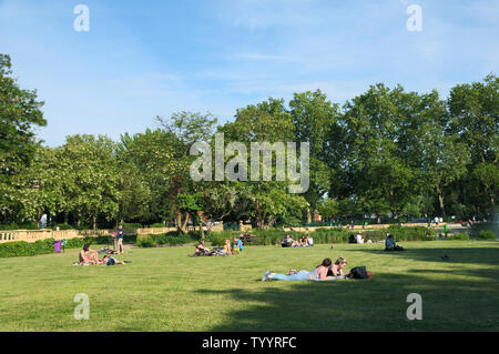People relaxing in the sunshine at Bishops Park in Fulham, London, England, UK Stock Photo