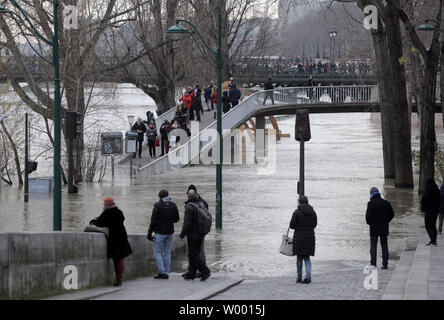 Residents check the swollen waters of the Seine river following torrential rains in Paris on January 27, 2018. The French capital remained on flood alert after the river burst its banks, leaving streets flooded and forcing part of the lower level of the famous Louvre Museum to close. Photo by Maya Vidon-White Stock Photo
