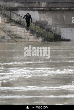 A resident checks the swollen waters of the Seine river following torrential rains in Paris on January 27, 2018. The French capital remained on flood alert after the river burst its banks, leaving streets flooded and forcing part of the lower level of the famous Louvre Museum to close. Photo by Maya Vidon-White Stock Photo