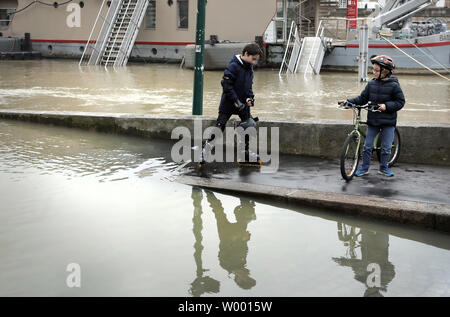Residents check the swollen waters of the Seine river following torrential rains in Paris on January 27, 2018. The French capital remained on flood alert after the river burst its banks, leaving streets flooded and forcing part of the lower level of the famous Louvre Museum to close. Photo by Maya Vidon-White Stock Photo