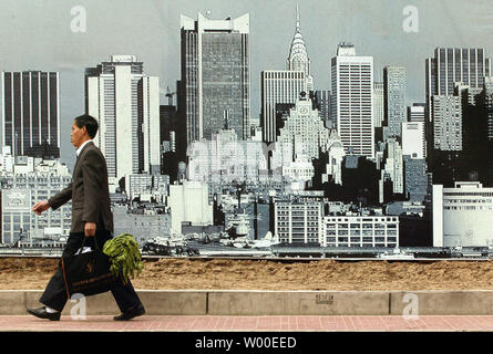 A Chinese businessman, and his vegetables, pass a giant billboard advertising a new, 'New York' style residential complex, in Beijing, April 27, 2006.  A surge in the number of vacant, newly built apartments suggests China's real estate market may be facing a financial fallout, reports said Tuesday.  China had 123 million square meters (1.3 billion sq. feet) of unsold and unleased space in new buildings by the end of March, a rise of about 24 percent over a year earlier.  Beijing, Shanghai and other major Chinese cities are evicting millions of residents as they raze older housing in the city Stock Photo