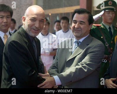 Afghan President Hamid Karzai shakes hands with Yuan Dahua, the Qing governor of Xinjiang, in Urumqui, Xinjiang Province, China on June 21, 2006.  China and Afghanistan signed 12 agreements in Beijing Tuesday during Afghan President Hamid Karzai's China visit, pledging to strengthen bilateral security and economic cooperation. The agreements, according to a joint statement, covered political cooperation, security matters, a military training program, a campaign against cross-border crime, economic and trade cooperation, investment, tariffs, aviation, agriculture, and cultural heritage protecti Stock Photo