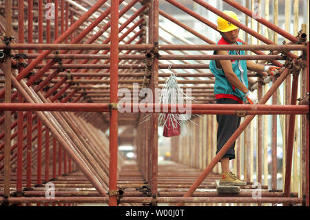 Chinese construction workers stands on scaffolding erected to build an Olympic exhibit at Beijing's Tiananmen Square on July 09, 2008.    (UPI Photo/Stephen Shaver) Stock Photo