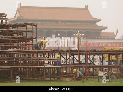 Chinese construction workers stand on scaffolding erected to build an Olympic exhibit amid haze at Beijing's Tiananmen Square on July 9, 2008.   (UPI Photo/Stephen Shaver) Stock Photo