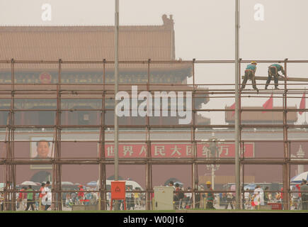 Chinese construction workers stand on scaffolding erected to build an Olympic exhibit amid haze at Beijing's Tiananmen Square on July 9, 2008.   (UPI Photo/Stephen Shaver) Stock Photo