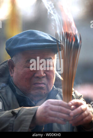 Chinese pray at a temple as China celebrates the Lunar New Year in Beijing January 29, 2009. Tens of millions of Chinese around the world celebrate the Lunar New Year, one of the most important traditional holidays.  Incense sticks are lit, fireworks are set off and families and friends gather for meals in Chinese communities to ring in the Year of the Ox. (UPI Photo/Stephen Shaver) Stock Photo