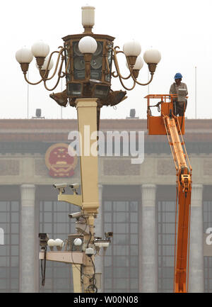 A Chinese worker cleans giant light bulbs, checks out a mass of closed circuit video cameras and checks the wiring of large lamp post on Tiananmen Square, ahead of the 60th anniversary of the founding of Communist China this October 1, in Beijing on August 18, 2009.  The renovation is part of preparations for October's 60th anniversary, with the main highlight being a massive parade by the People's Liberation Army (PLA) through the centre of Beijing.   UPI/Stephen Shaver Stock Photo