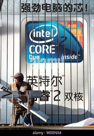 Two Chinese workers install a massive computer billboard, featuring IBM laptops bundled with Microsoft software, at a electronics store in Beijing on December 18, 2009.  China will become Microsoft's biggest market within the next seven years, according to Bill Gates.     UPI/Stephen Shaver Stock Photo