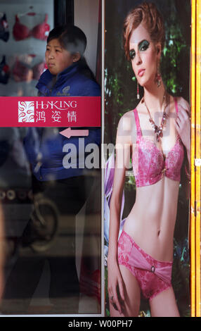 A Chinese saleswoman waits for customers at a Western-style woman's clothing store in Beijing on March 20, 2010.       UPI/Stephen Shaver Stock Photo