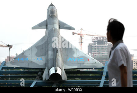 Chinese walk past a Chinese fighter jet on display in front of a main military aviation ministry complex in downtown Beijing on June 06, 2010.  The United States appealed to China on Saturday to restore military ties despite discord over U.S. arms sales to Taiwan and said it was considering options beyond the United Nations to punish North Korea over the sinking of a South Korean naval ship.     UPI/Stephen Shaver Stock Photo