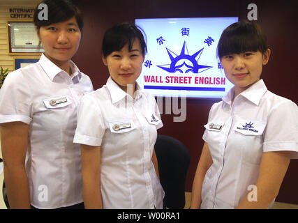 Chinese 'language workshop managers' work at a downtown branch of Wall Street English, a private language school, in Beijing on July 12, 2010. China's capital has become the latest mainland city keen on beefing up the English skills of its residents as part of the government's effort to be more cosmopolitan.  All government employees under the age of 40 will also be required to master at least 1,000 basic English sentences for their daily work.    UPI/Stephen Shaver Stock Photo