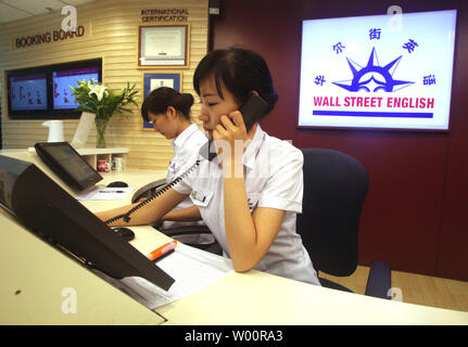 Chinese 'language workshop managers' work at a downtown branch of Wall Street English, a private language school, in Beijing on July 12, 2010. China's capital has become the latest mainland city keen on beefing up the English skills of its residents as part of the government's effort to be more cosmopolitan.  All government employees under the age of 40 will also be required to master at least 1,000 basic English sentences for their daily work.    UPI/Stephen Shaver Stock Photo