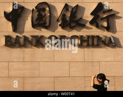 A Chinese woman walks past the Bank of China's headquarters in Beijing September 24, 2010.  U.S. President Barack Obama urged Chinese Premier Wen Jiabao to speed up the revaluation of America's currency, telling him in a two-hour meeting Thursday that the slow pace of reforms was affecting both the global and U.S. economies.     UPI/Stephen Shaver Stock Photo