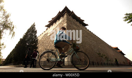 A Chinese man cycles past China's former imperial palace, the Forbidden City, on a warm spring day in Beijing on May 10, 2011.  For almost five hundred years, the Forbidden City served as the home of the emperors, as well as the ceremonial and political center of Chinese government.  It is the world's largest surviving palace complex.    UPI/Stephen Shaver Stock Photo