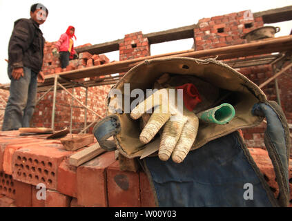 Relocated, poor rural farmers, under the direction of the Ningxia Ecological Migration Program, build a small village for resettlement in Yongning County, a frontier area in the northwestern province Ningxia Hui Autonomous Region on September 23, 2011.  Ningxia has built 25 migration settlements since 1983, allocating over 55,000 hectares of arable land to 412,000 poverty-stricken farmers.  The government-sponsored partial migration project to relocate poor farmers living in the arid and frigid southern mountains to the Yellow River irrigation areas is aimed at fundamentally changing and impro Stock Photo