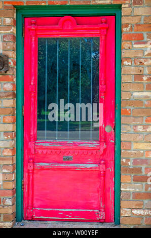 A vintage wooden door is painted red, June 23, 2019, in Meridian, Mississippi. Stock Photo