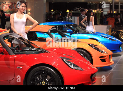 chinese models pose next to lotus sports cars during a pre opening day show at the worlds biggest automobile show being held in beijing on april 25 2012 china is the worlds largest automobile and parts market with international car makers setting up massive plants and dealerships across the country in hopes of gaining a share of the fast growing domestic market upistephen shaver w010nm